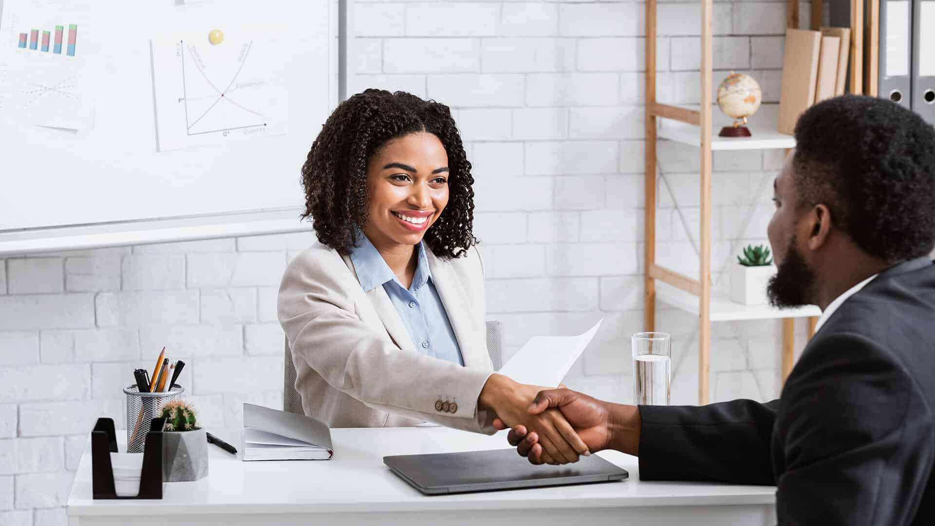 Black personnel  Management. Black personnel  Management in Africa. Black personnel  Management in Africa photo. African disabled job candidate and mature female Employer Shaking hands and smiling at Camera.